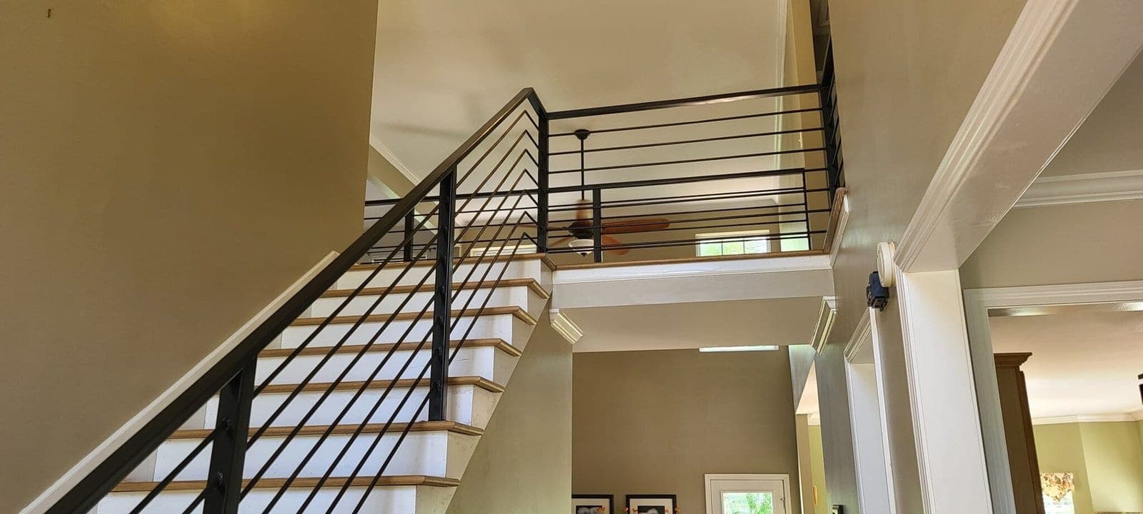 Cable railing along an interior staircase and upper landing