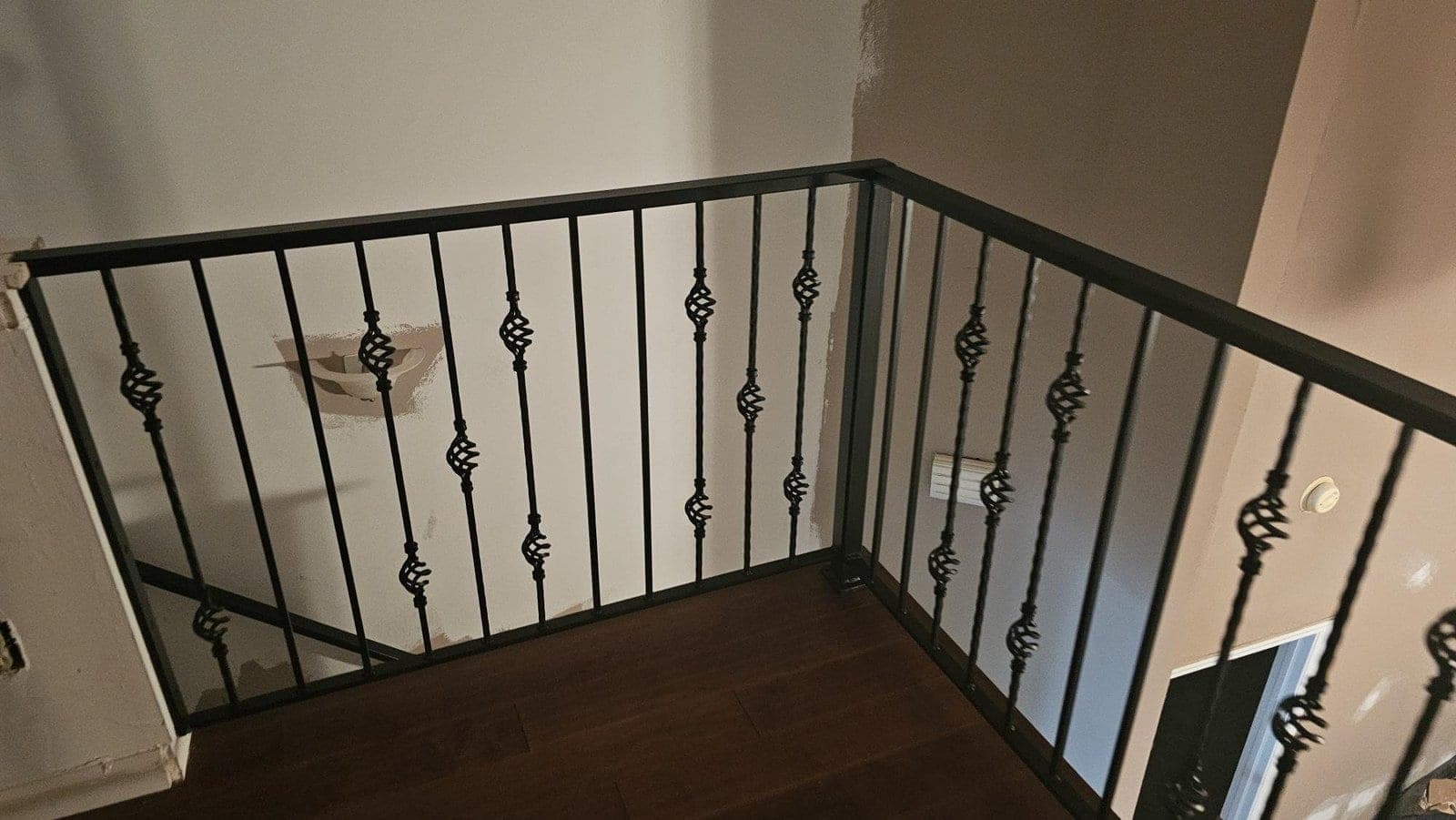 Indoor landing railing with twisted metal balusters and decorative details